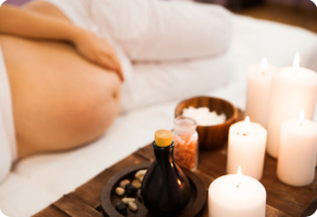 femme enceinte couchée sur le côté avec ambiance de bougie femme enceinte qui prend soin d'elle avec bougies et des produits naturels